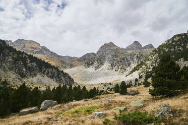 From above rough rocky of Garmo Negro mountain range covered with grass located against blue sky in nature of Aragon Pyrenees in Spain - ADSF48187