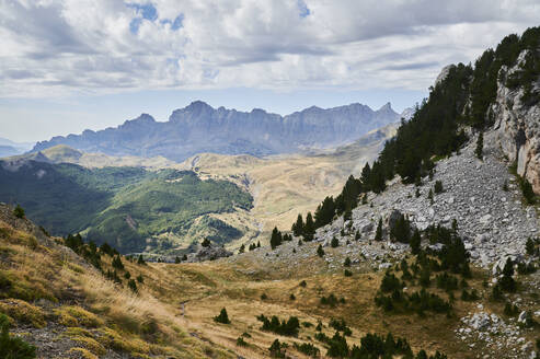 From above rough rocky of Pena Foratata mountain range covered with grass located against blue sky in nature of Aragon Pyrenees in Spain - ADSF48193