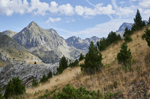 From above rough rocky of Pena Foratata mountain range covered with grass located against blue sky in nature of Aragon Pyrenees in Spain - ADSF48194