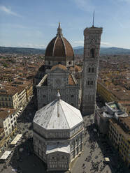 Aerial view of city and Cathedral of Santa Maria Del Fiore with largest dome surrounded with orange tile roof residential buildings in Florence Italy - ADSF48223