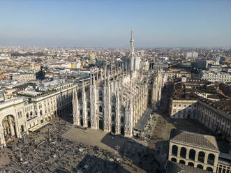 Aerial view of Milan with crowd near old buildings and Metropolitan Cathedral-Basilica of Nativity of Saint Mary in Italy in daylight - ADSF48229