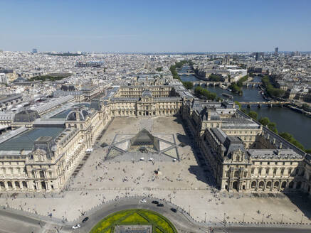 Aerial view of cityscape of Paris with aged Louvre museum against cloudless blue sky in sunlight - ADSF48236