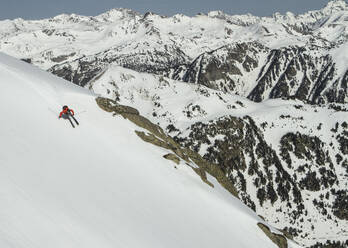 Top view of anonymous man riding skis on snowy mountain on winter day - ADSF48256