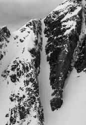 Picturesque landscape of rocky rough mountains covered with snow against stormy sky during winter day - ADSF48262