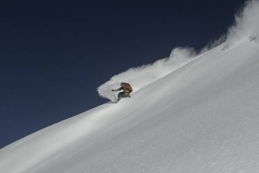 Side view of unrecognizable sportsman riding snowboard on snowy mountain in winter - ADSF48266