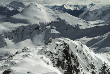 Picturesque view of rocky snowy mountains located against grey sky in winter on Ushuaia Argentina - ADSF48288