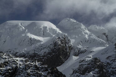 Picturesque view of rocky snowy mountains located against grey sky in winter on Ushuaia Argentina - ADSF48293