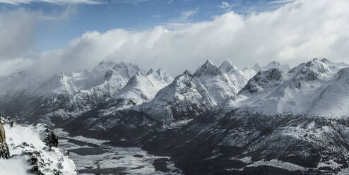 Picturesque view of rocky snowy mountains located against cloudy sky in winter on Ushuaia Argentina - ADSF48295
