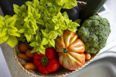 From above of various assorted fresh vegetables placed in wicker basket on white background - ADSF48369