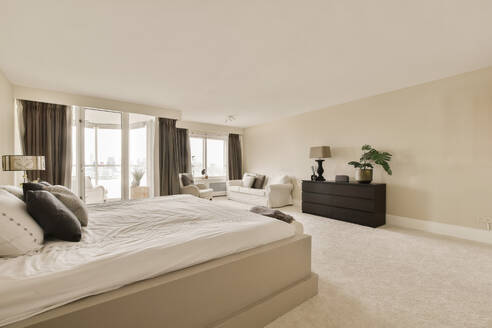 Interior of master bedroom with large bed and white sheets in contemporary apartment - ADSF48469
