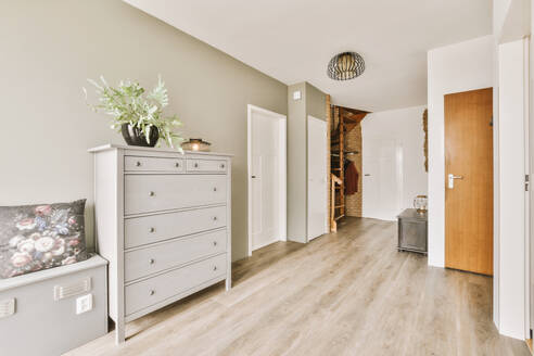 Interior of living room with white dresser and hallway in contemporary light apartment - ADSF48473