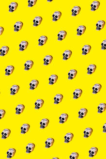 Vector illustration of small human skulls with creepy paint placed in symmetrical rhomb on vibrant yellow background - ADSF48499