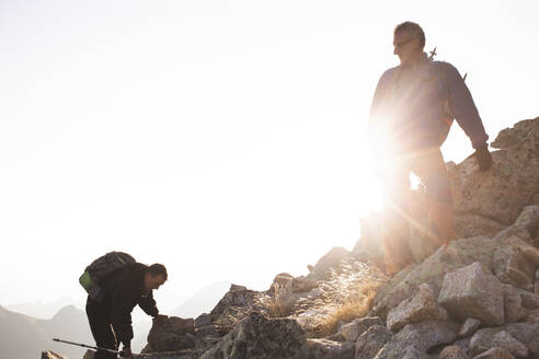 Freunde klettern auf einem felsigen Berg an einem sonnigen Tag - PCLF00863