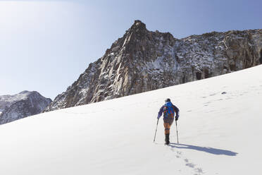 Mann geht auf Schnee vor Bergen - PCLF00865