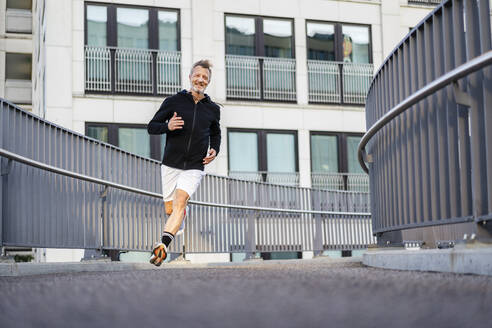 Mature athlete running on bridge - DIGF20887