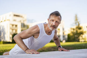 Active sportsman practicing push-ups in park - DIGF20892