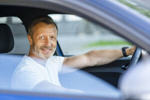 Smiling man sitting in car - DIGF20897
