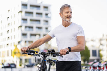 Contemplative man with electric bicycle - DIGF20921