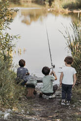 Kinder angeln am Wochenende gemeinsam am Seeufer - ANAF02276