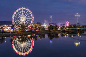 Deutschland, Baden-Württemberg, Stuttgart, Cannstatter Wasen, Glühendes Riesenrad spiegelt sich im Neckar bei Nacht - WDF07414