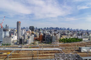 Japan, Präfektur Osaka, Osaka City, Zug wartet am Bahnhof mit Wolkenkratzern in der Innenstadt im Hintergrund - THAF03259