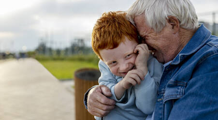 Glücklicher Großvater umarmt seinen Enkel im Park - MBLF00012