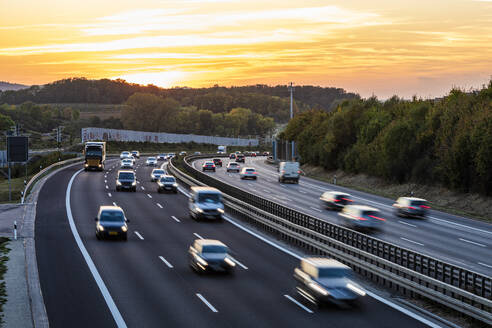 Deutschland, Baden-Württemberg, Kirchheim unter Teck, Verkehr auf der Bundesautobahn 8 bei Sonnenuntergang - WDF07418