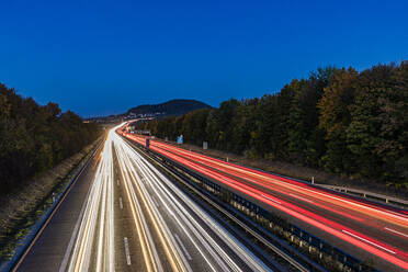 Germany, Baden-Wurttemberg, Aichelberg, Vehicle light trails on Bundesautobahn 8 at dusk - WDF07421