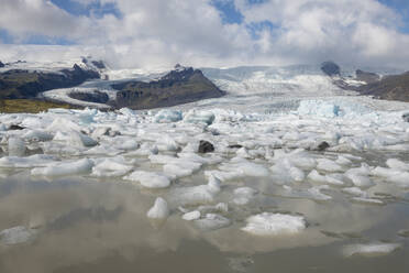 Iceland, Icebergs in Fjallsarlon lake with Vatnajokull glacier in background - RUEF04162
