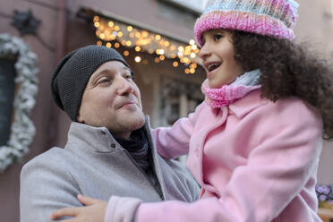 Lächelnder Vater mit Tochter auf dem Weihnachtsmarkt - VIVF01083