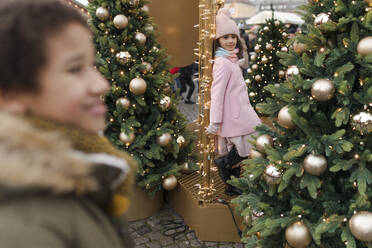 Junge mit Mädchen bei Weihnachtsbäumen auf dem Markt - VIVF01096
