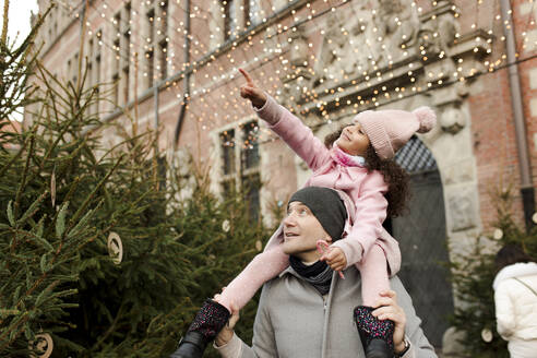 Smiling daughter gesturing and sitting on father's shoulders - VIVF01108