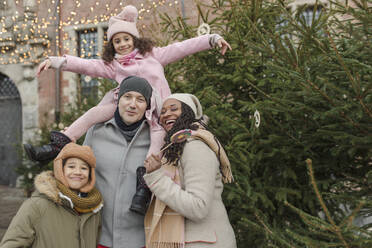 Glückliche Familie, die sich in der Nähe des Weihnachtsbaums amüsiert - VIVF01112