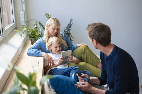 Father and mother with son using tablet PC at home - JOSEF21523