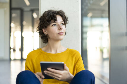 Nachdenkliche Geschäftsfrau sitzt mit Tablet-PC im Büro - JOSEF21623