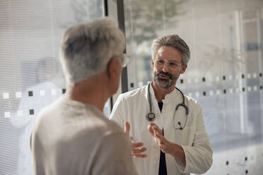 Senior doctor discussing with man in hospital - JOSEF21661