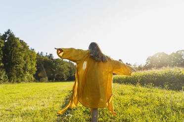 Girl walking with arms outstretched on grass - NDEF01236