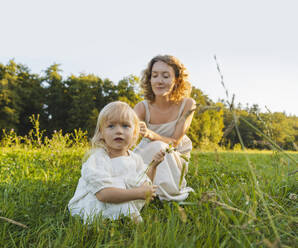 Mother and daughter spending time together on grass - NDEF01247