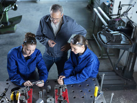 Ausbilder bei der Ausbildung von Lehrlingen an CNC-Werkzeugen in der Werkstatt - CVF02599
