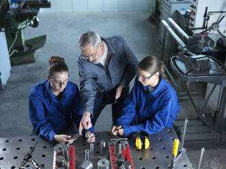 Instructor assisting trainees using CNC tools at workshop - CVF02601