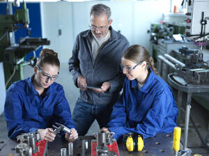 Ausbilder beobachtet Auszubildende bei der Verwendung von CNC-Werkzeugen in der Werkstatt - CVF02605