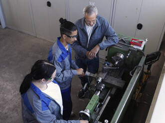 Apprentices learning lathe machine with instructor at workshop - CVF02610