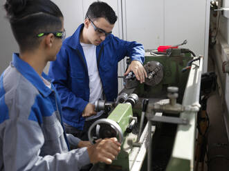 Trainees operating lathe at workshop - CVF02628