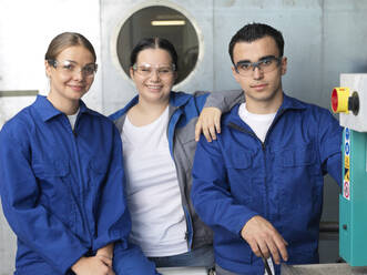 Smiling apprentices wearing protective eyeglasses at workshop - CVF02632