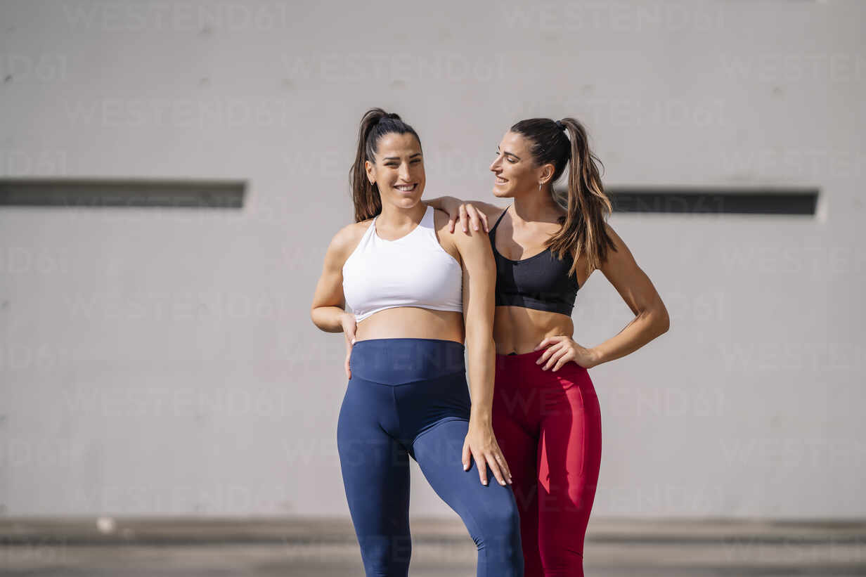 Woman in Sports Bra and Leggings Standing by the Wall · Free Stock Photo