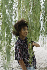 Junge Frau inmitten von Zweigen stehend - BOYF01995