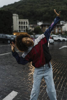 Smiling young woman dancing in rain - BOYF02013