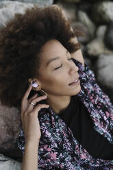 Frau entspannt sich und hört Musik über kabellose In-Ear-Kopfhörer - BOYF02054