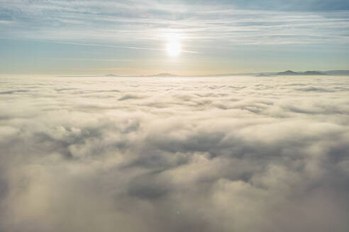 Breathtaking aerial view over white thick and soft clouds floating against mountain peaks - ADSF48650