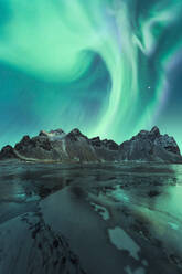 Picturesque view of frozen surface of water and small mountain ridge on background of amazing polar lights - ADSF48672